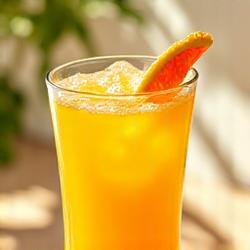 Segelas jus campuran sitrus berwarna kuning cerah dengan irisan buah jeruk.