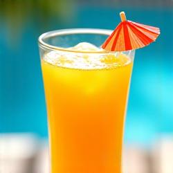 Segelas jus tropika dengan mangga dan nanas, hiasan payung koktail.